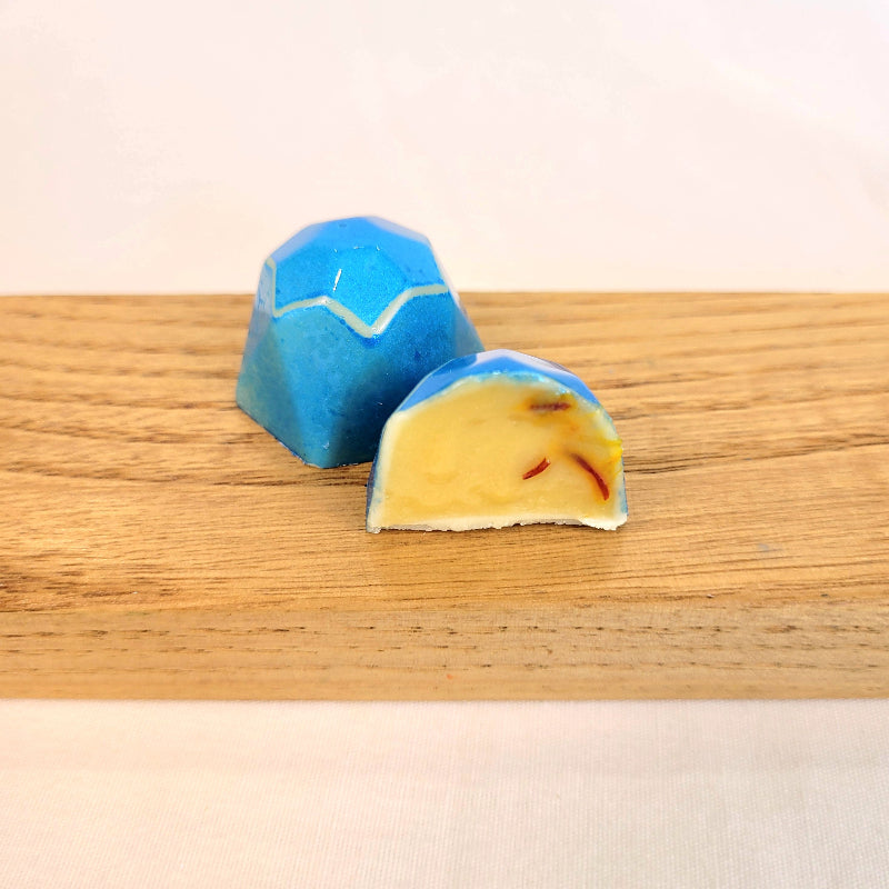 blue geometric-shaped bonbon flavored with saffron and honey cut open to see inside