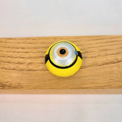 chocolate bonbon painted to look like a yellow minion eye