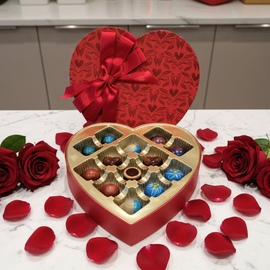 Heart-shaped chocolate box with a variety of chocolates on a marble surface