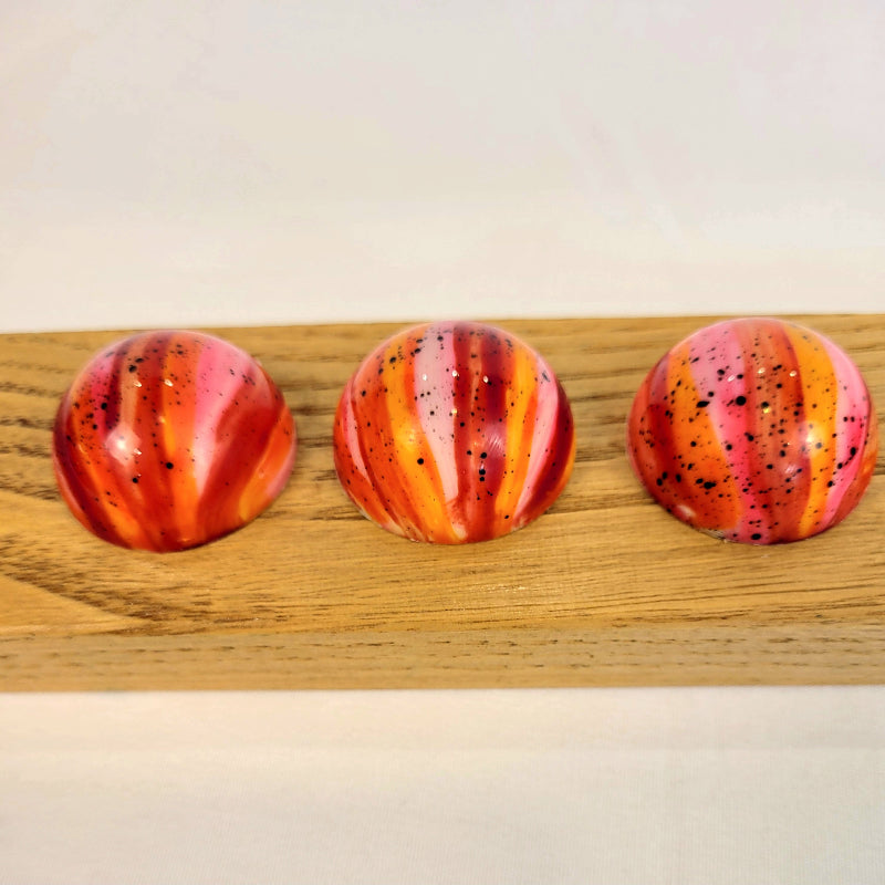 Cranberry orange anise flavored bonbons in pink, orange, and red
